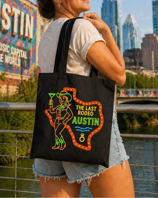 Woman holding a tote bag with 'The Last Rodeo Austin' design, standing in front of a cityscape with 'Austin' mural.