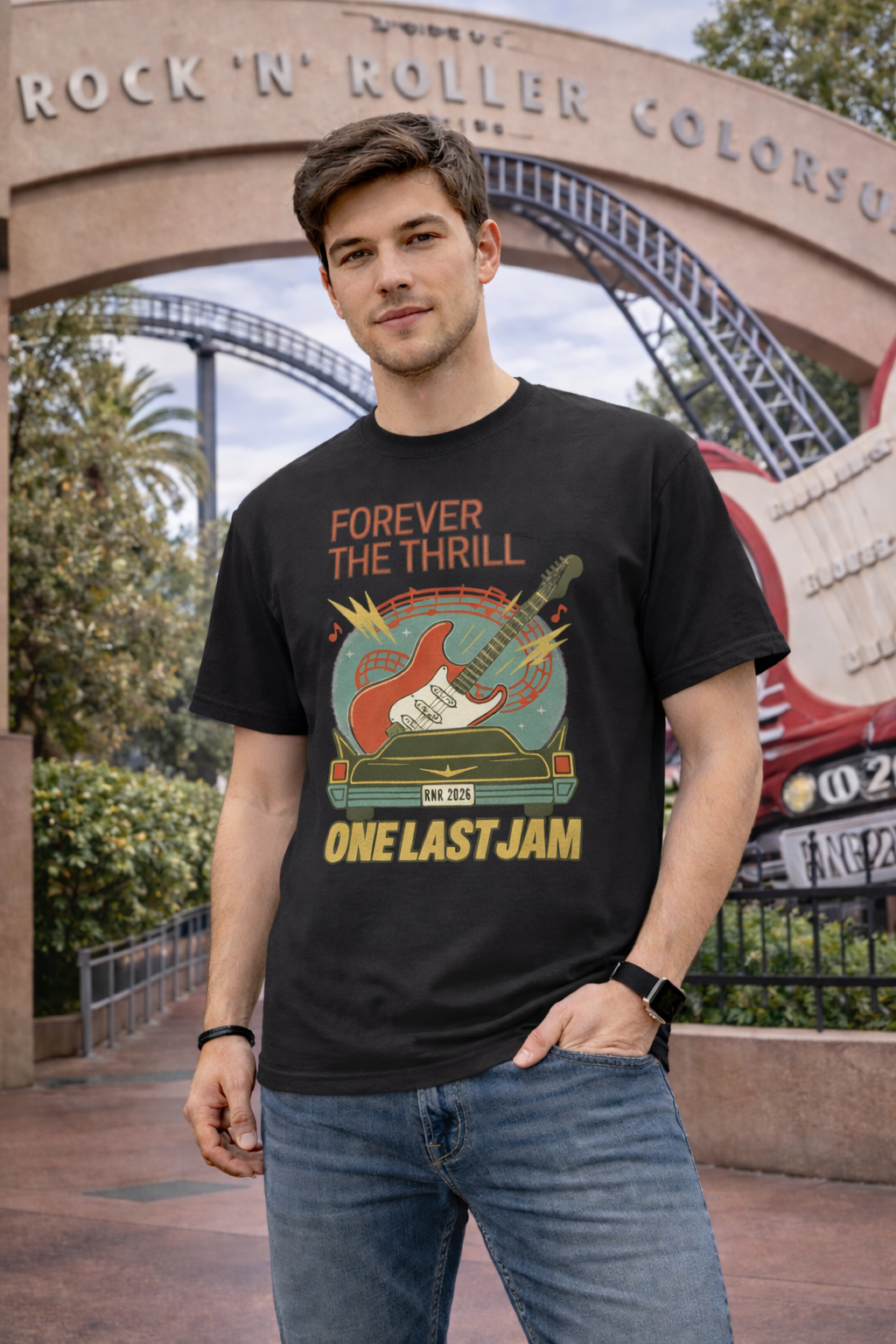 Man wearing a black t-shirt with graphic design and text, standing in front of a themed archway.