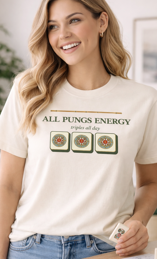 Woman wearing a t-shirt with text that says "All pung energy" and mahjong graphics, standing in a casual indoor setting.