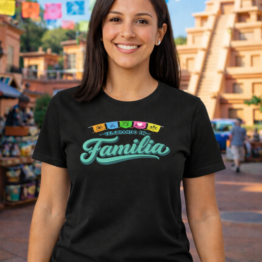 Woman wearing a black t-shirt with 'Familia' text in a themed area with colorful flags and buildings.