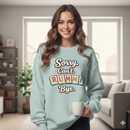 Woman wearing a light blue sweatshirt with text that says "Sorry. Can't.Rummi. Bye", holding a mug in a living room.