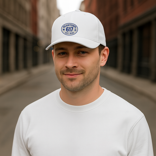 Man wearing a white cap with a 617 logo and text, standing on a street.