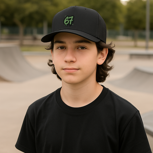 Young person wearing a black cap with a 67 green logo at a skate park.