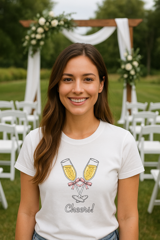 Woman wearing a white t-shirt with champagne glass design and cheers in an outdoor setting