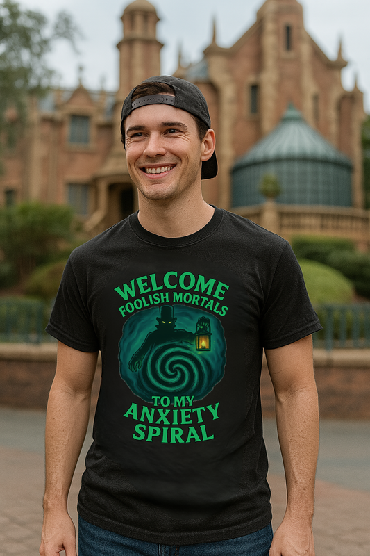 Man wearing a black Gildan 64000 t-shirt with green text ‘Welcome Foolish Mortals to My Anxiety Spiral’ featuring a ghostly figure holding a lantern and a swirling spiral background.