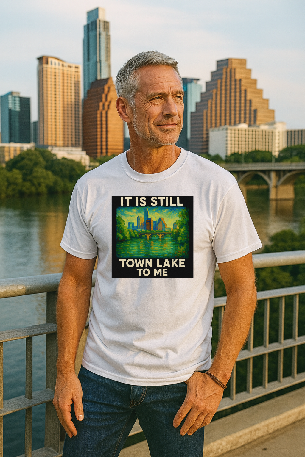 Man wearing a white t-shirt that says "it is still town lake to me" with a standing by a waterfront with a Austin skyline in the background.