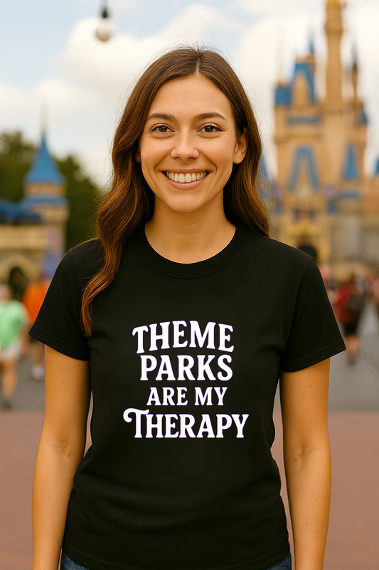 Person wearing a black t-shirt with 'Theme Parks Are My Therapy' text in front of a theme park castle.