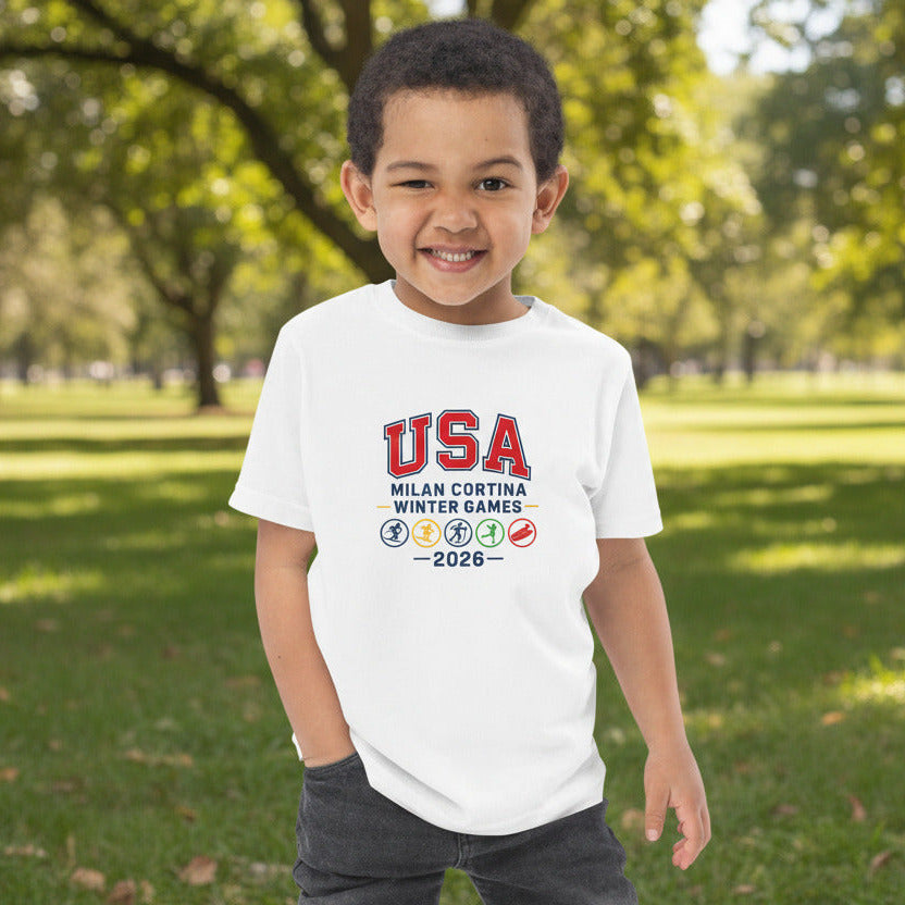 Child wearing a white t-shirt with 'USA Milan Cortina Winter Games 2026' text on a white background